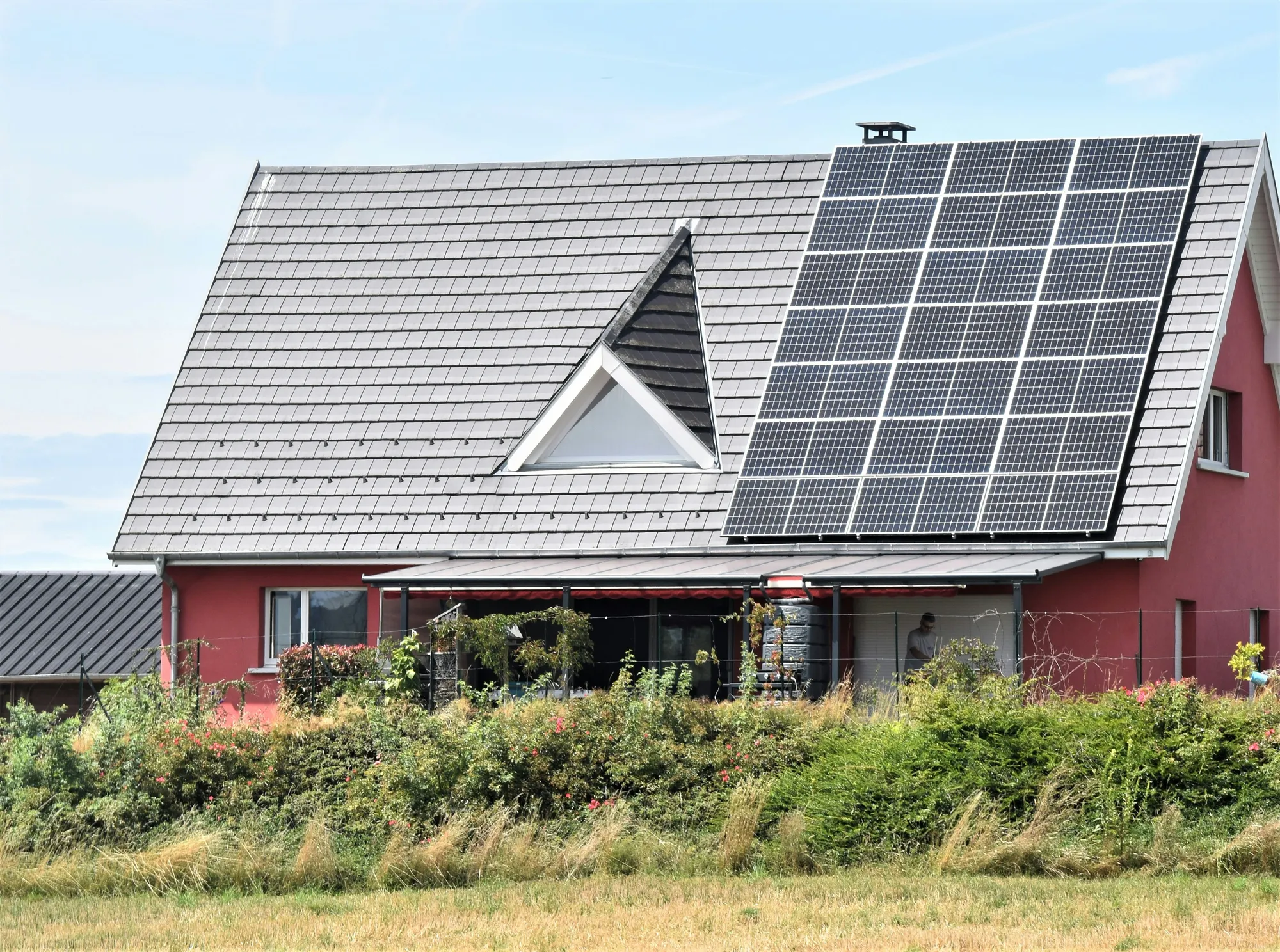 Solar panels on a house roof under a clear sky