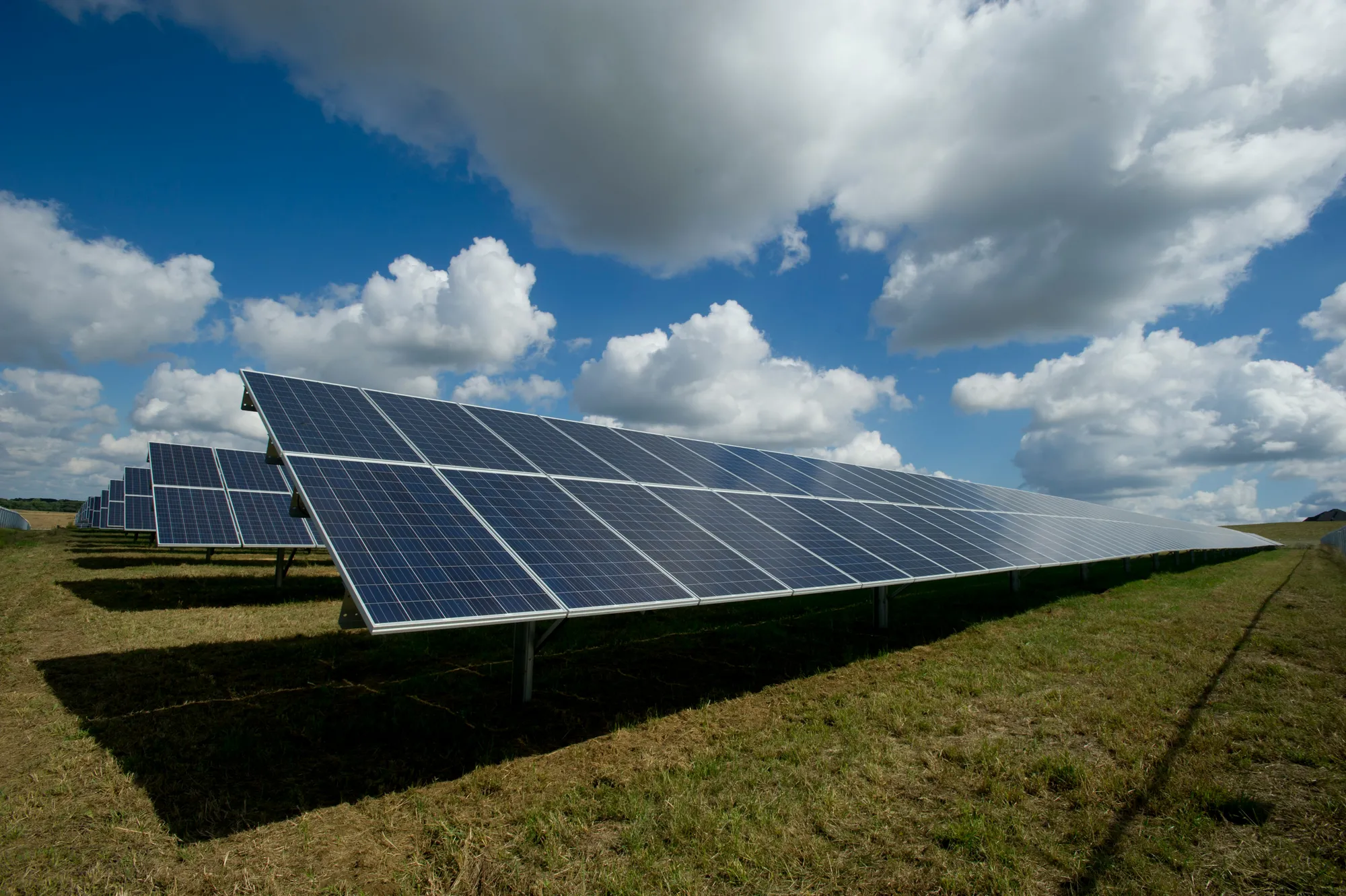 Ground-mounted solar park in rows, cloudy sky